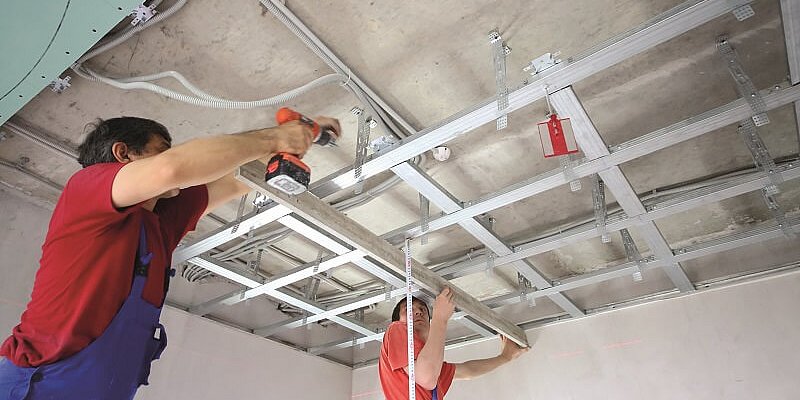 Bauarbeiter bei Installation von Materialien an der Decke