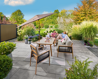 Zwei Personen sitzen an einem sonnigen Tag im Garten auf der Terrasse und unterhalten sich