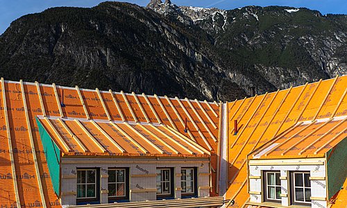 Arbeiter bei der Konstruktion eines Dachgrundgerüstes mit Holz