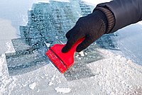 Eiskratzer auf zugefrorener Autoscheibe